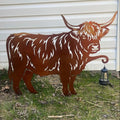 Metal sculpture of a longhorn cow in front of a white wall